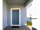 Blue front door with white trim and a black doormat at 1166 Aloha Blvd, Davenport, FL 33897