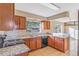 Galley style kitchen with wood cabinets, granite countertops, and black appliances at 618 El Camino Real S, Lakeland, FL 33813