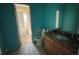 Bathroom with teal walls, wood vanity, and toilet at 2331 Olney Rd, Lakeland, FL 33801