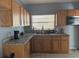 L-shaped kitchen with wood cabinets and granite counters at 2331 Olney Rd, Lakeland, FL 33801