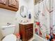 Bathroom with wood vanity and floral shower curtain at 151 Pine St, Babson Park, FL 33827