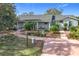 Quaint house with a green exterior, landscaping, and a long driveway at 151 Pine St, Babson Park, FL 33827
