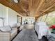 Covered porch with tropical mural, wicker furniture, and ceiling fan at 151 Pine St, Babson Park, FL 33827