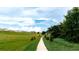 Scenic community path meanders through grassy landscape, offering peaceful views of homes and lush greenery at 4776 Cloister St, Kissimmee, FL 34758