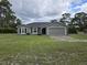 Gray house with a two-car garage and large yard at 42202 Royal Trails Rd, Eustis, FL 32736