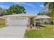 Tan house with a two-car garage and landscaped yard at 2739 Everleth Dr, Lakeland, FL 33810
