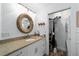 Bathroom with granite countertop, built-in shelving, and laundry closet at 10801 Sw 185Th Ter, Dunnellon, FL 34432