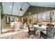 Bright screened porch with seating and dining areas, overlooking backyard at 10801 Sw 185Th Ter, Dunnellon, FL 34432