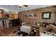 Spacious living room features a brick accent wall, comfortable seating, and hardwood floors at 3200 River Ranch Blvd # 204, River Ranch, FL 33867