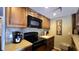 Well-equipped kitchen with dark wood cabinets, modern appliances, and mosaic backsplash at 3200 River Ranch Blvd # 204, River Ranch, FL 33867
