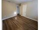 Well-lit bedroom, showcasing wood-look floors and access to hallway at 1911 High St, Leesburg, FL 34748