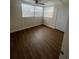 Bright bedroom with wood-look floors, window blinds, and a door at 34936 3Rd Ave, Leesburg, FL 34788