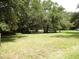 Large lot with lush green grass and mature trees at 217 Catalonia Ave, De Leon Springs, FL 32130