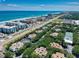 Aerial view of beachfront community with pool, tennis court, and lush landscaping at 4150 S Atlantic Ave # 107C, New Smyrna Beach, FL 32169