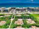 Aerial view of oceanfront community with lush landscaping and tennis courts at 4150 S Atlantic Ave # 107C, New Smyrna Beach, FL 32169