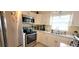 Kitchen with white cabinets, stainless steel appliances, and window at 9 Villa Villar Ct, Deland, FL 32724