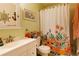 Bathroom with floral shower curtain, white vanity, and neutral colors at 9 Villa Villar Ct, Deland, FL 32724