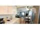 Kitchen with view into living room, white cabinets, and quartz countertops at 9 Villa Villar Ct, Deland, FL 32724