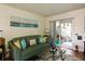 Living room with green sofa, glass coffee table, and sliding door leading to outdoor space at 9 Villa Villar Ct, Deland, FL 32724