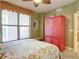 Bedroom with floral bedding, large window, and red armoire at 2403 S Atlantic Ave # 409, Daytona Beach Shores, FL 32118