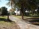 House exterior showing driveway, landscaping, and mature trees at 207 E 2Nd Ave, Pierson, FL 32180