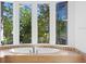 Oval soaking tub and double vanity in a bright bathroom with garden views at 5994 Seminole Woods Dr, Port Orange, FL 32127