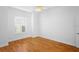 Bright bedroom with hardwood floors, ceiling fan, and plantation shutters at 5994 Seminole Woods Dr, Port Orange, FL 32127