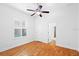 Bedroom with hardwood floors, ceiling fan, and plantation shutters at 5994 Seminole Woods Dr, Port Orange, FL 32127