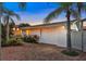 White house with brick paver driveway and tropical landscaping at 138 Old Carriage Rd, Ponce Inlet, FL 32127