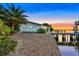 Expansive waterfront patio with lush landscaping and sunset views at 138 Old Carriage Rd, Ponce Inlet, FL 32127
