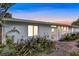White single story home with landscaped walkway, brick pavers, and lush foliage at dusk at 138 Old Carriage Rd, Ponce Inlet, FL 32127