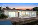 Waterfront home with sunroom and brick patio at sunset at 138 Old Carriage Rd, Ponce Inlet, FL 32127
