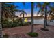 White house with brick paver driveway and tropical landscaping at 138 Old Carriage Rd, Ponce Inlet, FL 32127