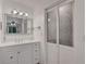 Clean bathroom with white vanity, mirror, and frosted glass doors at 138 Old Carriage Rd, Ponce Inlet, FL 32127