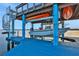Boat lift with kayaks and a spiral staircase leading to a deck at 138 Old Carriage Rd, Ponce Inlet, FL 32127