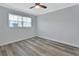 Bright bedroom with wood-look flooring, window, and ceiling fan at 217 N Hill Ave # 20, Deland, FL 32724