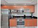 Modern kitchen with stainless steel appliances and wood cabinets at 241 Riverside Dr # 2205, Holly Hill, FL 32117