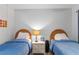 Twin bedroom with wicker headboards, nightstands, and blue bedding at 2700 Ocean Shore Blvd # 111, Ormond Beach, FL 32176