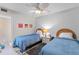 Guest bedroom with twin beds, ceiling fan, and beach-themed decor at 2700 Ocean Shore Blvd # 111, Ormond Beach, FL 32176