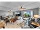 Living room with glass dining table, gray sofa and access to balcony at 2700 Ocean Shore Blvd # 111, Ormond Beach, FL 32176
