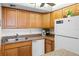 Kitchen area with wood cabinets, appliances and a view of the fridge at 2700 Ocean Shore Blvd # 111, Ormond Beach, FL 32176
