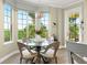Sunlit dining area with glass top table and four chairs near a balcony at 4672 Riverwalk Village Ct # 8201, Ponce Inlet, FL 32127