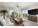 Open living room with hardwood floors, a large TV and lots of natural light at 4672 Riverwalk Village Ct # 8201, Ponce Inlet, FL 32127