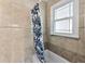 Clean bathroom with a shower/tub combo and window at 4111 S Atlantic Ave, Port Orange, FL 32127