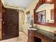 Bathroom with dark wood vanity and intricate carved door at 3580 Ocean Shore Blvd, Ormond Beach, FL 32176
