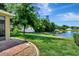 Landscaped backyard with a pond and brick patio at 605 Champions Gate, Deland, FL 32724