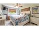 Main bedroom with a floral comforter, ceiling fan, and ensuite bathroom at 100 Talo Cir, Port Orange, FL 32127