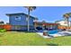 Spacious backyard with a pool, covered patio, and lush landscaping at 3 Wisteria Dr, Ormond Beach, FL 32176