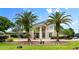 Two-story home with palm trees, stone accents, and a three-car garage at 1978 Country Club Dr, Port Orange, FL 32128