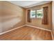 Simple bedroom with hardwood floors and neutral walls, featuring a large window at 41 Villa Villar Ct # 41, Deland, FL 32724